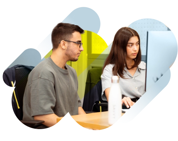 How it works - Savvy team Two people are sitting at a desk working on a computer, with a water bottle on the table. The background features abstract shapes.